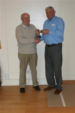 Bert presents Pat with the trophy for winning the skittles with a max score of 9